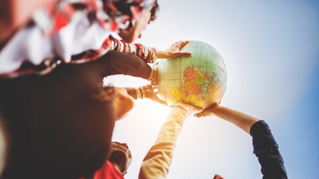 Multiple arms holding up a globe to the sky