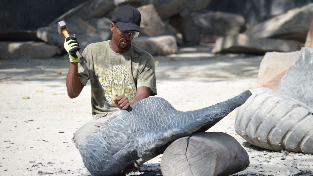 A stone mason artist working on a large stone